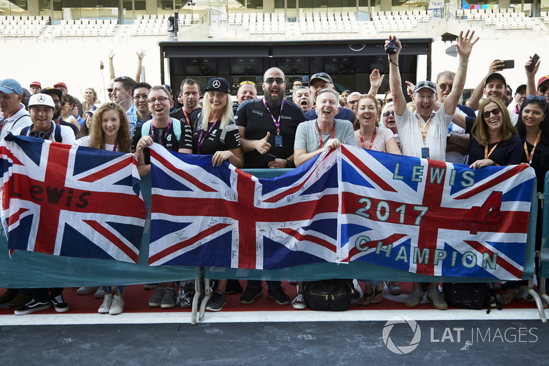 Fans of Lewis Hamilton, Mercedes AMG F1, wait outside the garage in the pit lane
