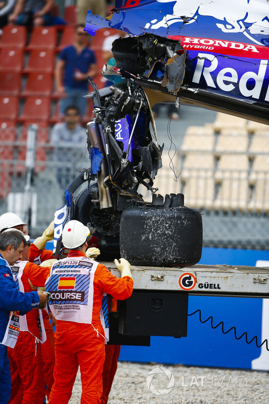 Marshals remove the damaged car of Brendon Hartley, Toro Rosso STR13, from the circuit as the gearbox hangs off the back