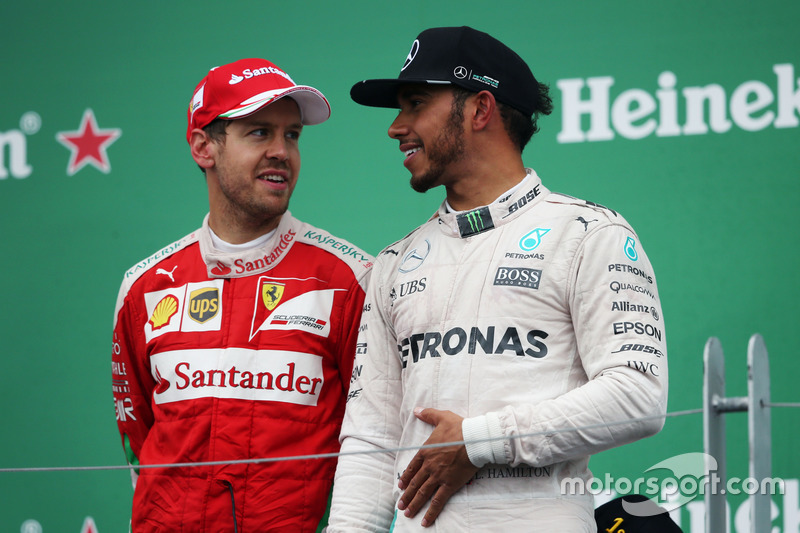 (L to R): Sebastian Vettel, Ferrari with race winner Lewis Hamilton, Mercedes AMG F1 on the podium