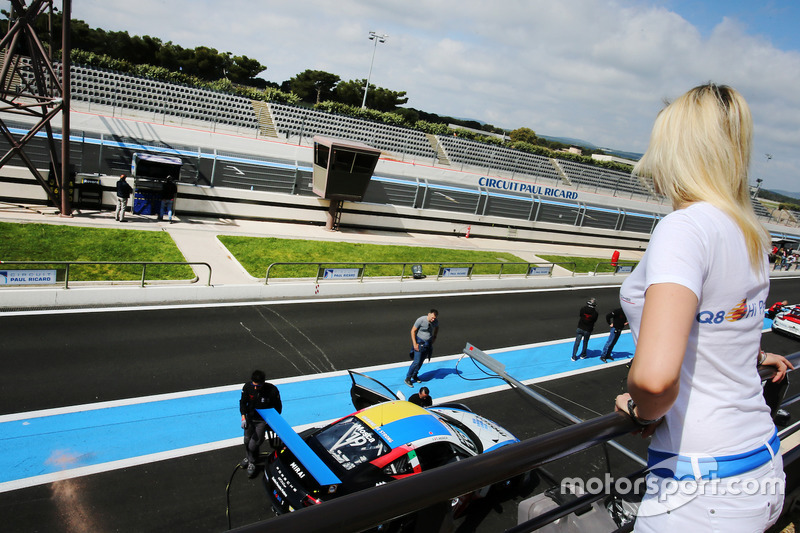 Una grid girl osserva le operazioni in pit lane