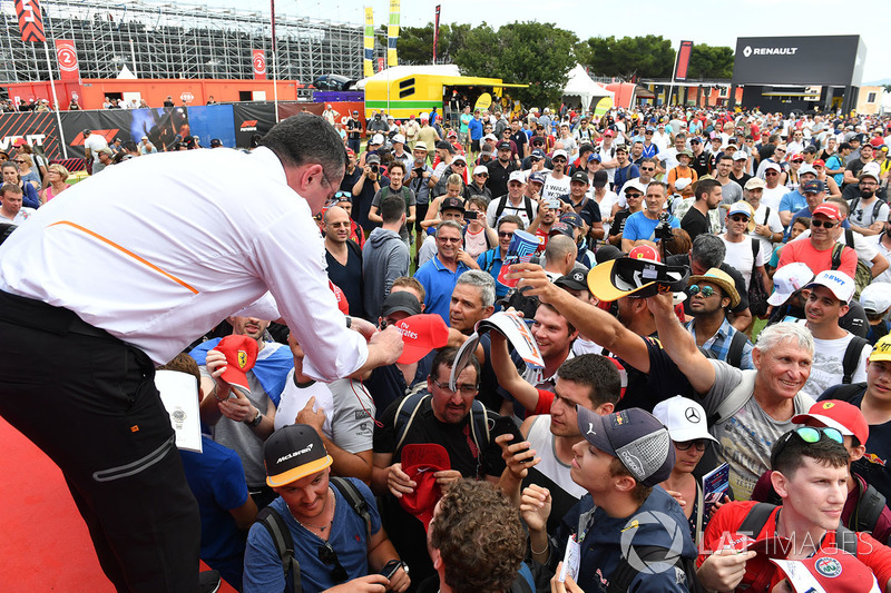 Éric Boullier, directeur de la compétition de McLaren, signe des autographes pour les fans