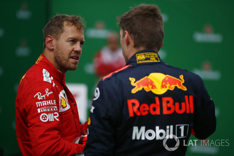 Sebastian Vettel, Ferrari, talks to Max Verstappen, Red Bull Racing