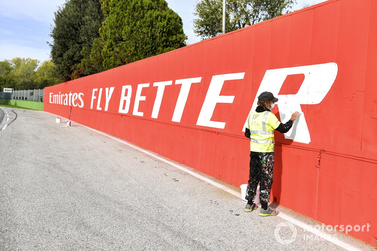 Un ouvrier peint les sponsors sur les murs