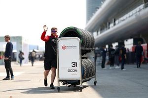 A Haas F1 team member in the Pitlane with a tyre cart 