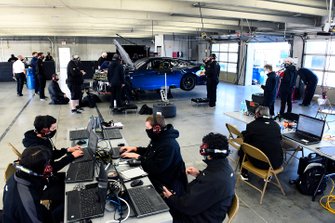 Team members make adjustments to the Nascar Next Gen car