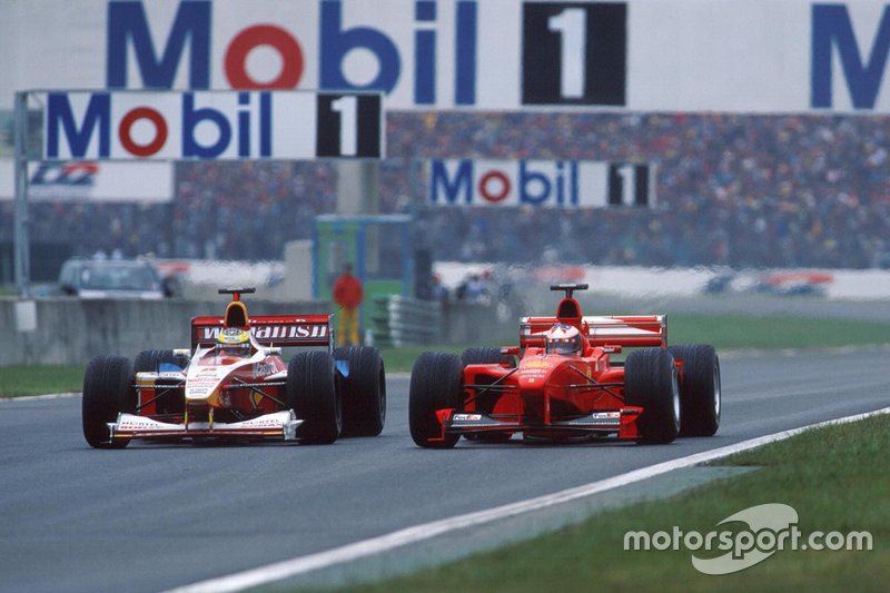 Ralf Schumacher, Williams FW21, makes a move on his brother Michael Schumacher, Ferrari F399