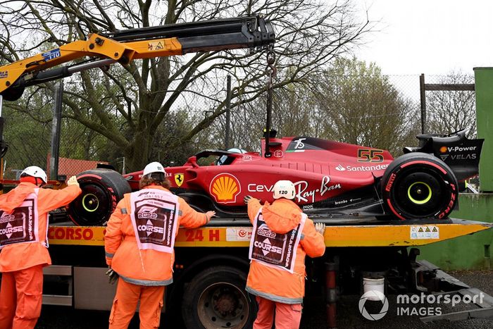 Oficiales de pista cargan el coche de Carlos Sainz Jr., Ferrari F1-75, en una grúa