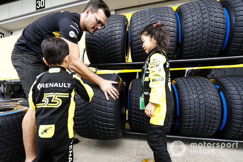 Young fans check out the Pirelli tyres of the Reanult team.