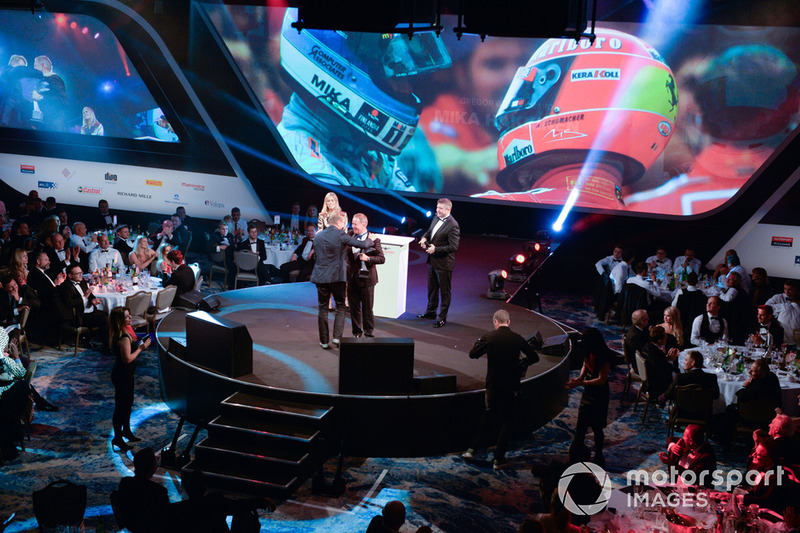 Mika Hakkinen receives a Gregor Grant Award from Martin Brundle on stage