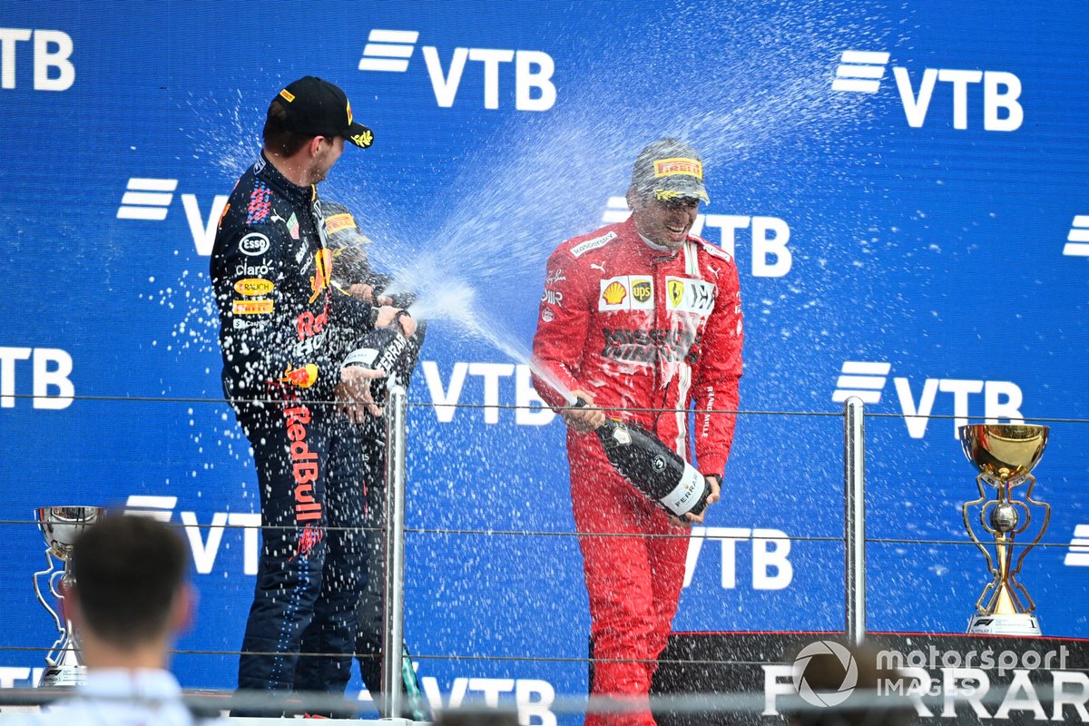 Max Verstappen, Red Bull Racing, secondo classificato, e Carlos Sainz Jr., Ferrari, terzo classificato, spruzzano Champagne sul podio