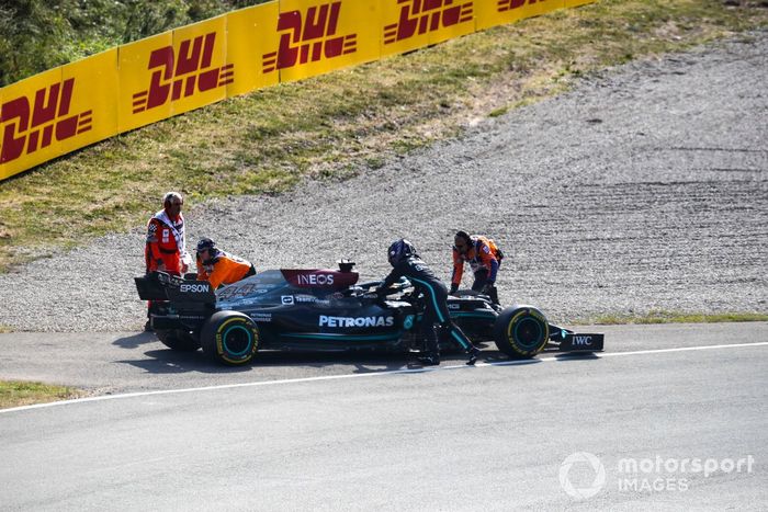 Los oficiales de pista asisten a Lewis Hamilton, de Mercedes, tras una avería en la FP2