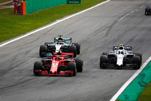 Kimi Raikkonen, Ferrari SF71H, Lewis Hamilton, Mercedes AMG F1 W09, as they put a lap on Sergey Sirotkin, Williams FW41 