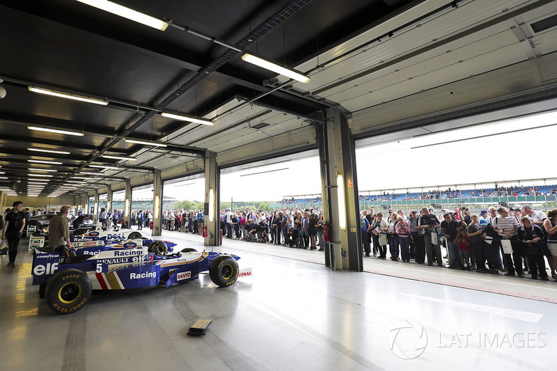 Fans view a garage filled with classic Williams F1 machinery