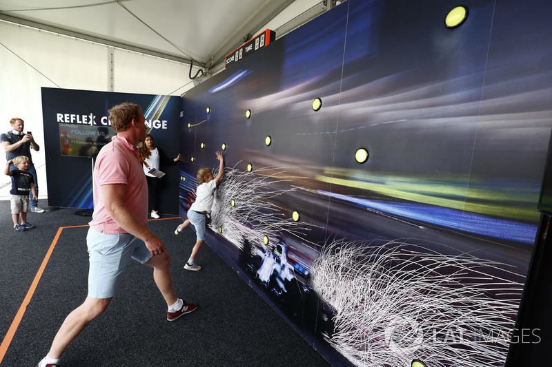 Los aficionados participan en el desafío de reflejo en el Fanzone de F1