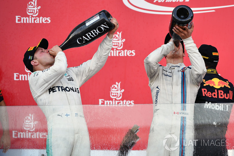 Valtteri Bottas, Mercedes AMG F1 e Lance Stroll, Williams festeggiano sul podio con lo champagne