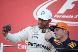 Race winner Lewis Hamilton, Mercedes AMG F1, takes a photo with Max Verstappen, Red Bull, second place, on the podium