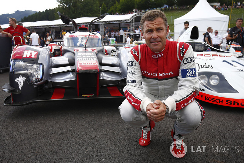 Tom Kristensen poses between an Audi LMP1 and Porsche 936