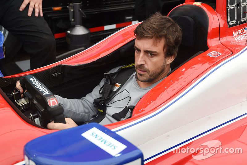 Fernando Alonso sits in the car of Marco Andretti