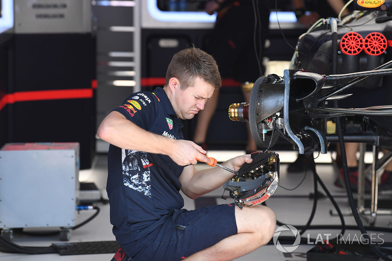 Red Bull Racing mechanic works on Red Bull Racing RB13 front brake and wheel hub