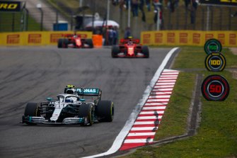 Valtteri Bottas, Mercedes AMG W10, voor Charles Leclerc, Ferrari SF90, en Sebastian Vettel, Ferrari SF90