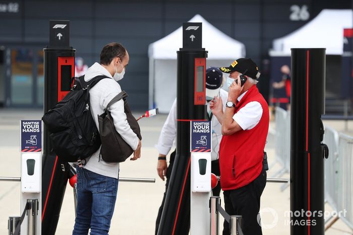 Robert Kubica, Alfa Romeo, muestra su pase a la entrada al paddock