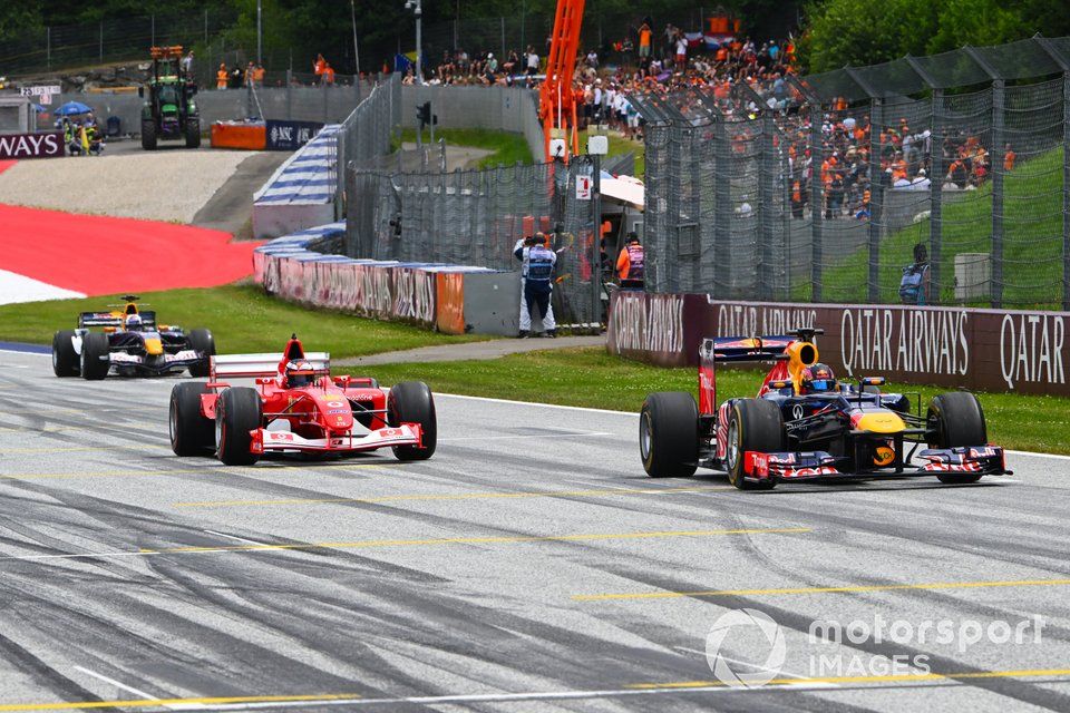 Patrick Friesacher prowadzi Red Bull RB8 Renault z 2012 r. w Paradzie Legend, wyprzedzając Gerharda Bergera, ex-Michaela Schumachera Ferrari F2002 z 2002 r. i Davida Coultharda, Red Bull RB1 z 2005 r.