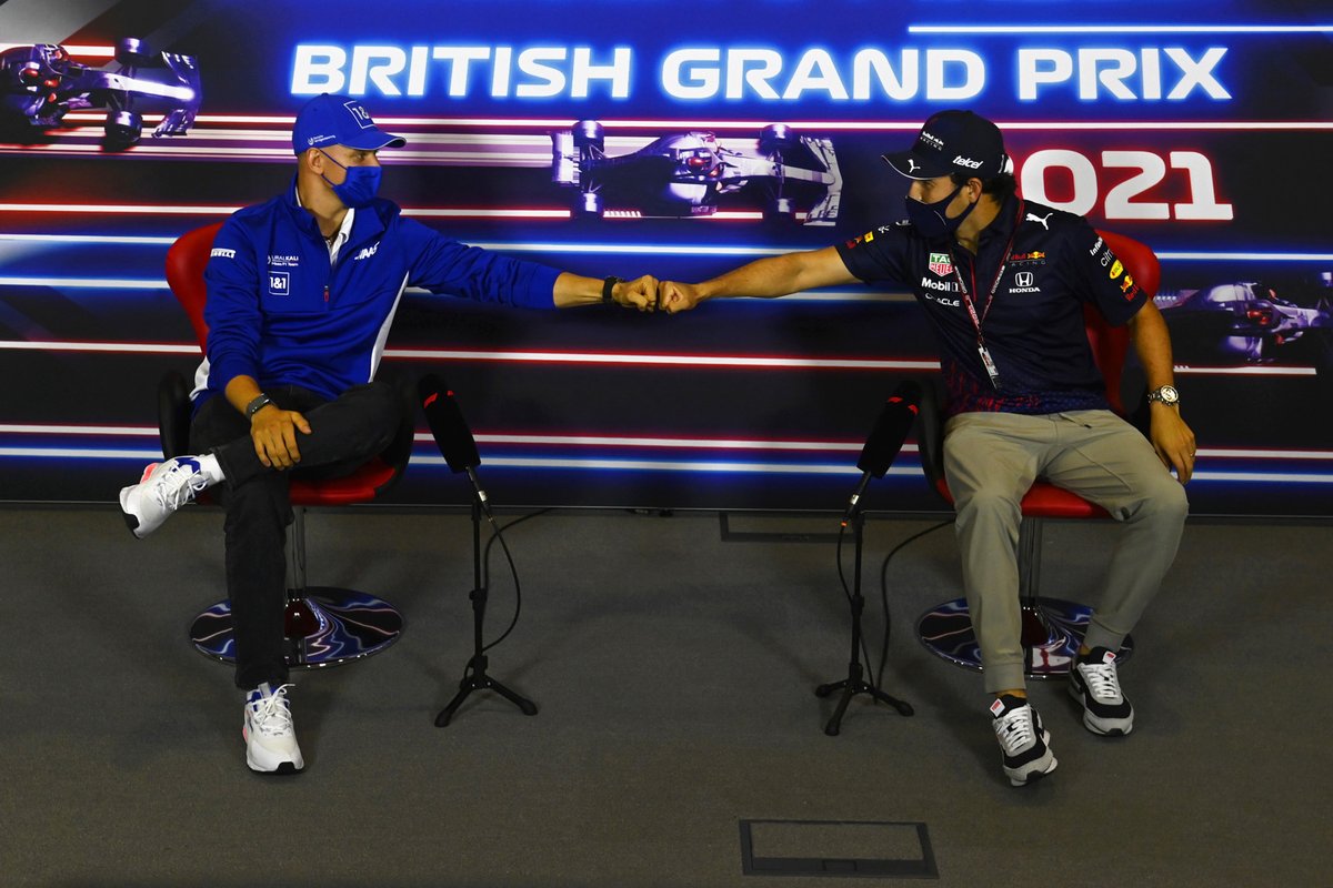 Mick Schumacher, Haas F1, bumps fists with Sergio Perez, Red Bull Racing, in the press conference