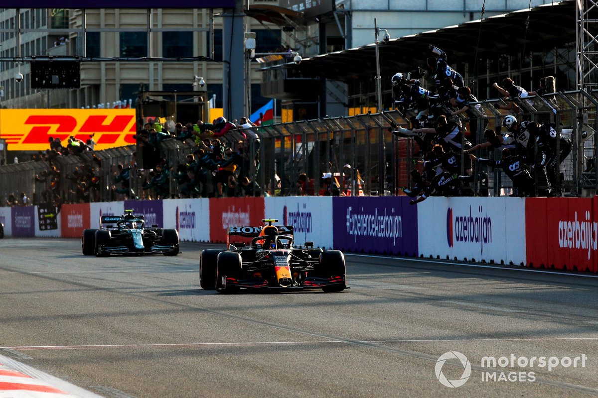 Sergio Perez, Red Bull Racing RB16B, 1° classificato, prende la bandiera a scacchi per la gioia della sua squadra al muretto dei box