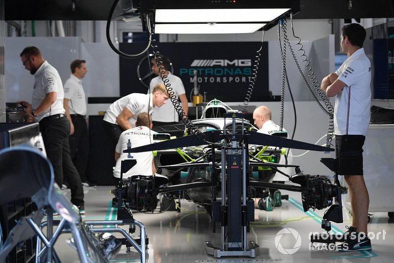 Des mécaniciens travaillent sur la voiture de Lewis Hamilton, Mercedes AMG F1 W10, dans le garage