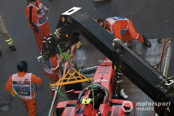 Los oficiales retiran el coche accidentado de Charles Leclerc, Ferrari SF90