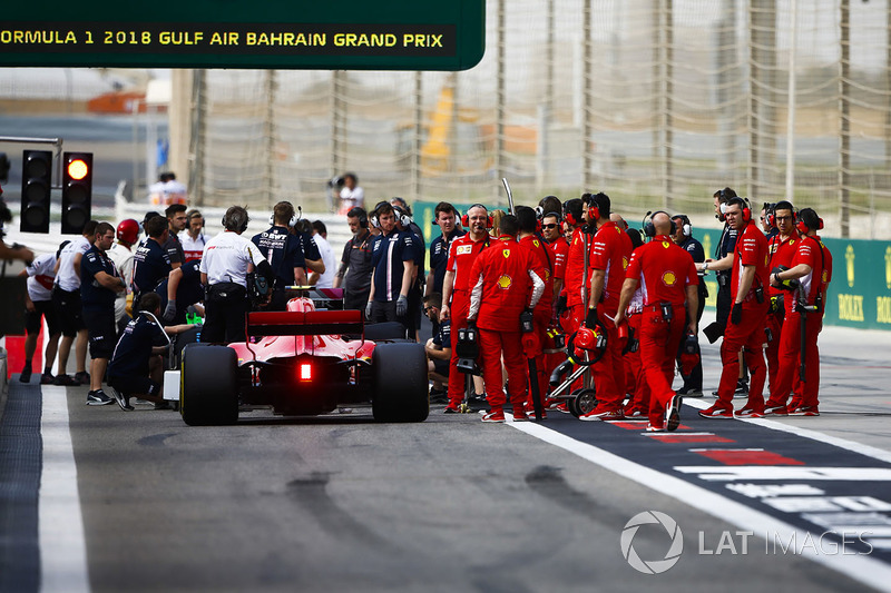 Kimi Raikkonen, Ferrari SF71H, and Ferrari engineers near the pit lane exit