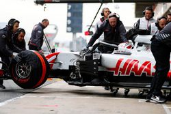 Kevin Magnussen, Haas F1 Team, is attended to by mechanics in the pit lane