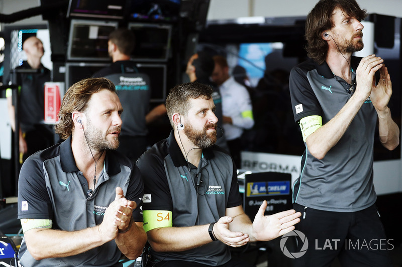 Jaguar Racing team members applaud in the garage