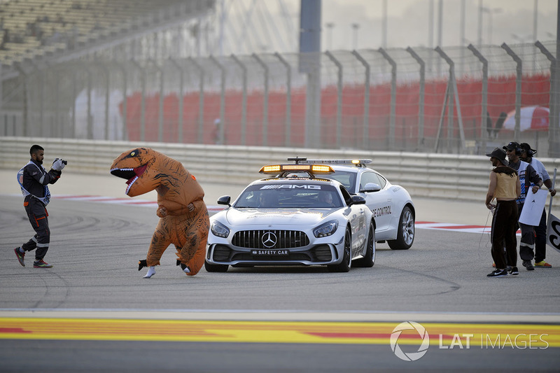 Oficiales de pista con un mensaje para Charlie Whiting, delegado de la FIA en el auto de seguridad que involucra a un dinosaurio