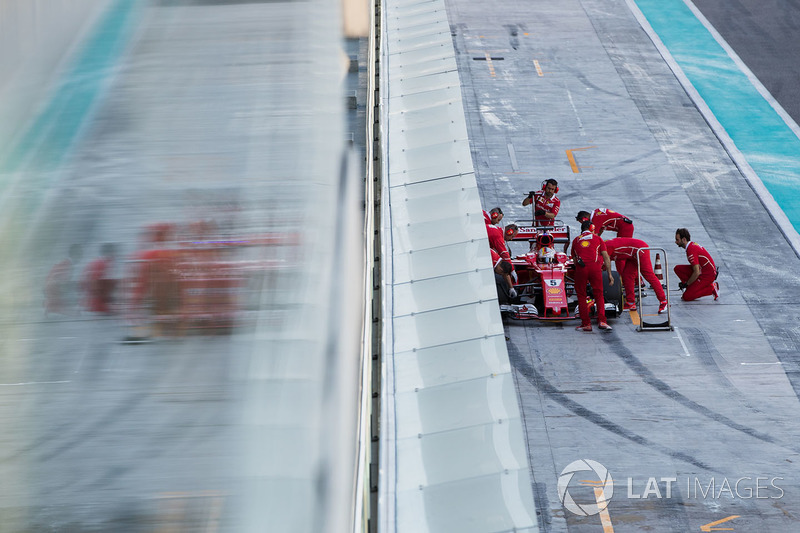 Sebastian Vettel, Ferrari SF70H, is attended to by mechanics in the pit lane