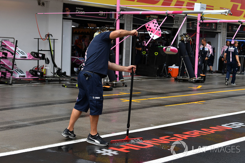 Un meccanico Force India F1 toglie l'acqua dalla piazzola box