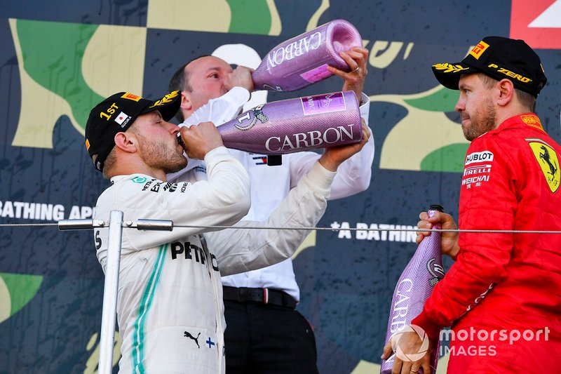 Sebastian Vettel, Ferrari, secondo classificato, e Valtteri Bottas, Mercedes AMG F1, primo classificato, festeggiano sul podio con lo Champagne
