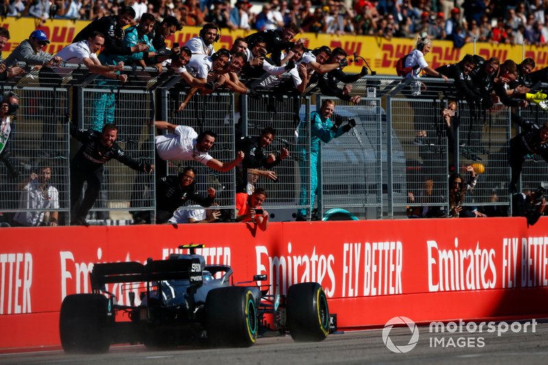 Valtteri Bottas, Mercedes AMG W10, 1ª posición, pasa a su equipo mientras celebran en el pit wall después de coger la bandera a cuadros