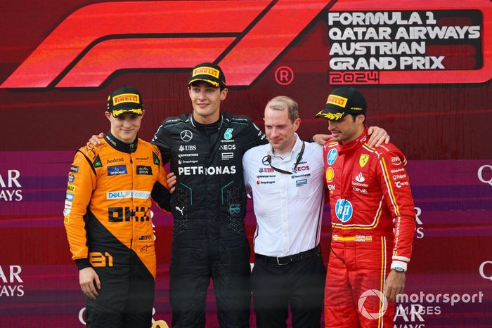 Oscar Piastri, McLaren F1 Team, 2ª posición, George Russell, Mercedes-AMG F1 Team, 1ª posición, el delegado de Mercedes en el trofeo y Carlos Sainz, Scuderia Ferrari, 3ª posición, en el podio.