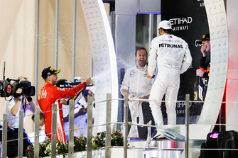 Sebastian Vettel, Ferrari, 2° classificato, e Lewis Hamilton, Mercedes AMG F1, 1° classificato, spruzzano l'acqua di rose verso Bradley Lord, direttore delle comunicazioni, Mercedes AMG, sul podio