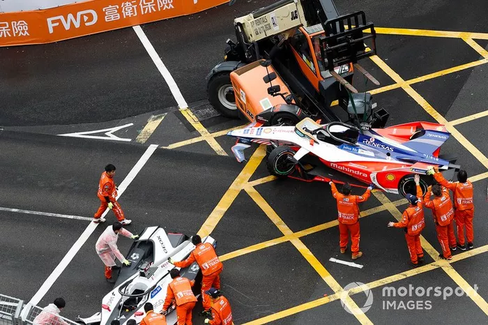 Los oficiales trabajan para mover el auto de Pascal Wehrlein, Mahindra Racing, M5 Electro así como el auto de Felipe Nasr, Dragon Racing Penske EV-3 