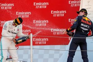 Racewinnaar Lewis Hamilton, Mercedes AMG F1 en Max Verstappen, Red Bull Racing op het podium met champagne