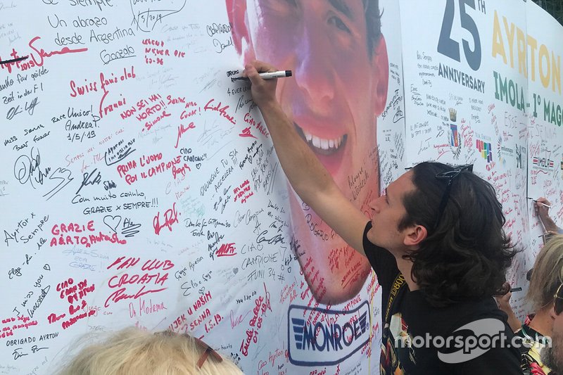 Un fifoso lascia un messaggio accanto alla foto di Ayrton Senna
