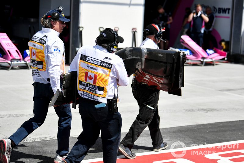 Los oficiales retiran el coche dañado de Kevin Magnussen, Haas VF-19, del circuito