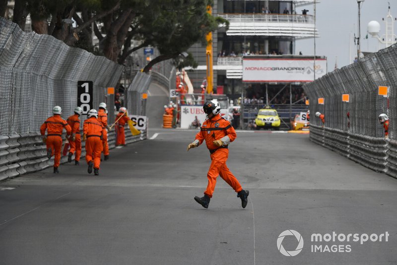 Oficiales de pista limpian el circuito