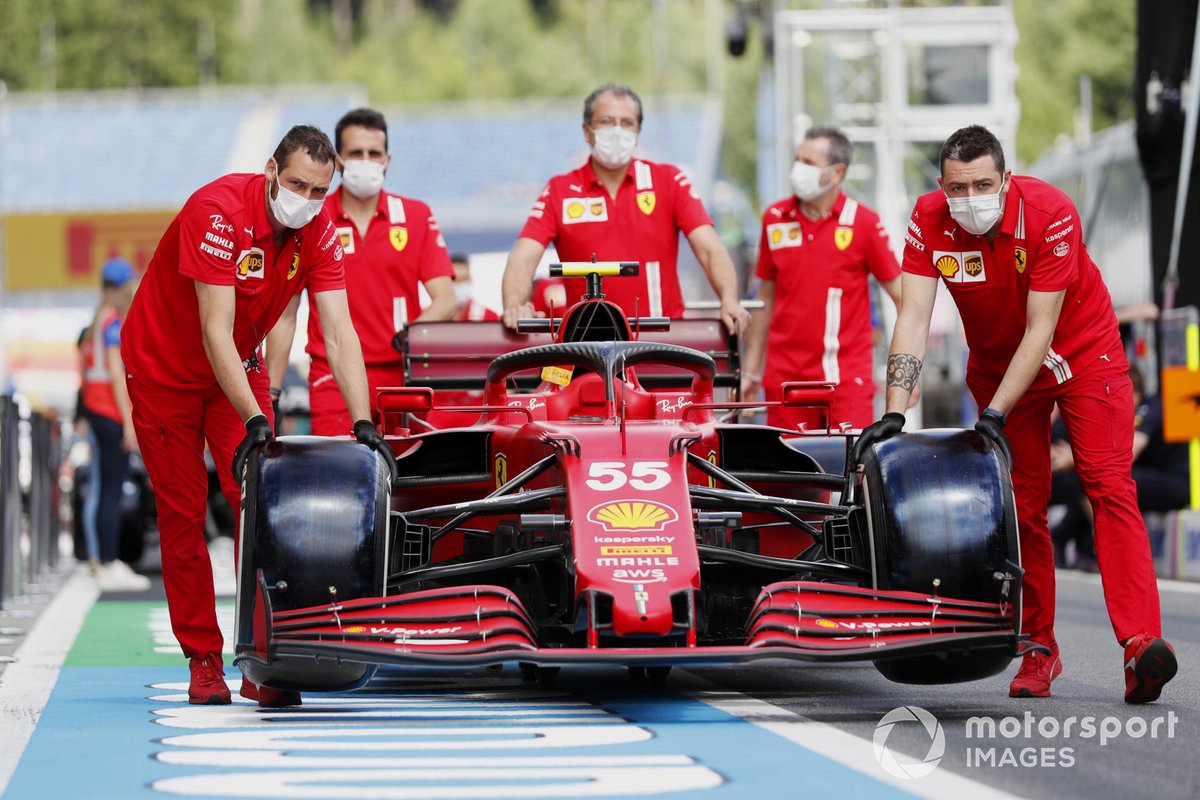 Ferrari mechanics push the car of Carlos Sainz Jr., Ferrari SF21, along the pitlane
