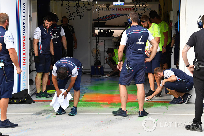 Los mecánicos de Williams limpian la parafina aerodinámica del piso del garaje
