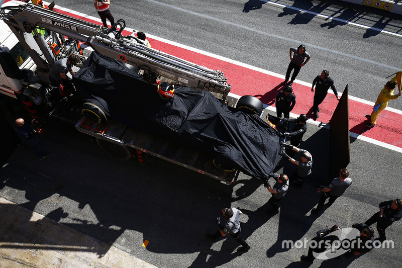 El McLaren MCL32 de Fernando Alonso vuelve al pitlane en un camión