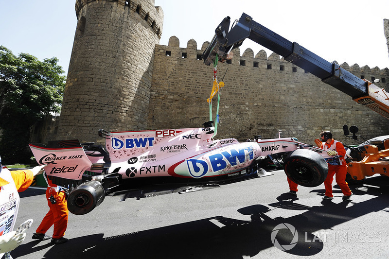 Marshals clear away the crashed Sergio Perez Sahara Force India F1 VJM10, a tow truck