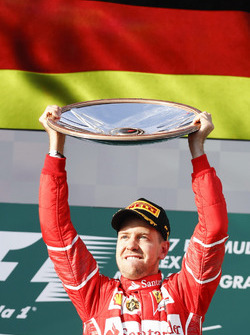 Sebastian Vettel, Ferrari, vainqueur, lève son trophée sur le podium